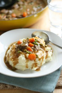 mashed potatoes with gravy, peas and carrots