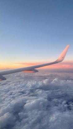 the wing of an airplane flying over clouds