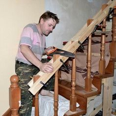 a man is working on some stairs with a planer and wood planks in his hand