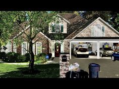 a blue car is parked in front of a brick house with two garages on each side