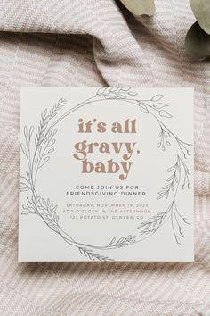 a baby announcement card on top of a blanket with greenery in the middle and it's all gravy, baby