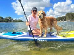 a woman and her dog on a paddle board in the water with their oars