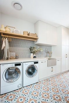 a washer and dryer sitting in a kitchen next to each other on top of a tiled floor