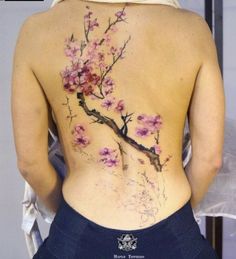 the back of a woman's body with pink flowers painted on her stomach and chest