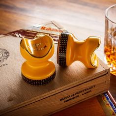 two yellow objects sitting on top of a wooden table next to a glass of beer