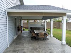 a covered patio with table and chairs on it