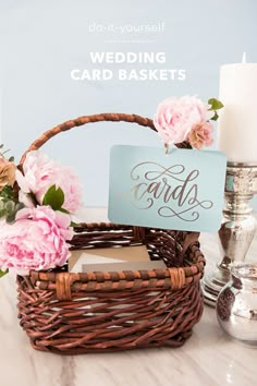 a basket filled with cards and flowers on top of a table next to a candle