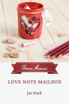 love note mailbox jar with hearts and pencils on the table next to it