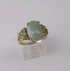 This is a 4.2 Gram 10K Yellow Gold Oval Jade Ring with Peridot Side Stones, size 7. It is pre owned but shows little if any wear.  Inventory #: R00090A Most rings are sizable for a small fee. If the ring you are considering is the incorrect size contact us for a quote. Payment Through Paypal within 3 days of purchase.   I ship to U.S addresses only. No international shipping.  Please Note: Due to a high number of returns on Items for no other reason than the buyer changes their mind or they just Multi-stone Oval Rings For May Birthstone, Oval Multi-stone Rings For May Birthstone, Oval Green Gemstones For Formal Occasions, Elegant Green Opal Oval Ring, Green Oval Opal Ring, Green Oval Cabochon 14k Stamped Jewelry, Oval Multi-stone Emerald Ring, Oval Multi-stone Jewelry For May Birthstone, Heirloom Emerald Ring With Gemstone Accents