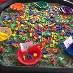 the tray is full of letters and numbers for children to play with in their classroom