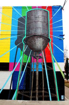 a large mural on the side of a building with a water tower painted on it