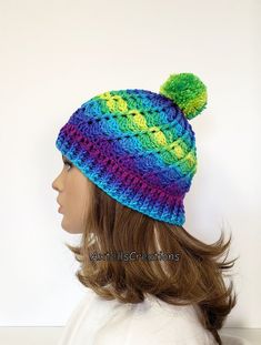 a woman wearing a multicolored knitted hat with pom - pom