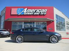 a car is parked in front of an american tire and tire store