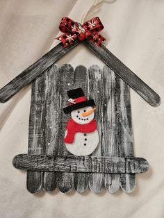 an ornament made to look like a house with a snowman on it