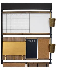 a wall mounted cork board with two cups and a calendar on it, next to a clipboard