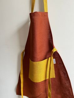 an orange and yellow apron hanging on the wall