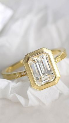 a diamond ring sitting on top of a white sheet