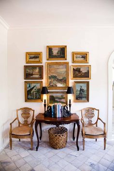 a living room filled with furniture and pictures on the wall above it's doorway