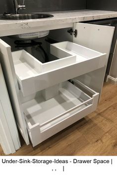 an under - sink storage area in a kitchen with drawers and cupboards underneath the sink