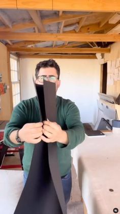 a man standing in front of a piece of black paper with his hands on it