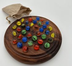 a wooden board game with colorful marbles on it