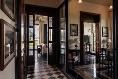 an entry way with black and white checkered flooring, framed pictures on the wall