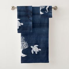 two towels hanging on a towel rack with sea animals and corals printed on them