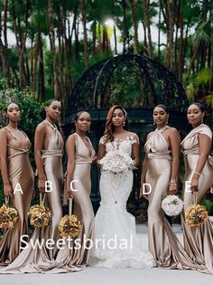 a group of women standing next to each other wearing dresses and holding bouquets in their hands