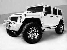 a black and white photo of a jeep with snow tires on it's tires