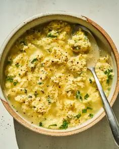 a white bowl filled with food next to a spoon