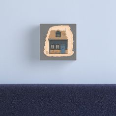 a blue house with a brown roof on the wall canvas print