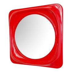 a red square shaped mirror sitting on top of a white wall