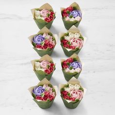 six flower bouquets arranged in different colors on a marble surface