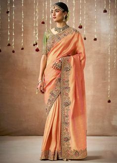 This free flowing saree gives you a charming and elegant look on drape. Simple, classy and comfortable for any wedding and festive. --------------------------------- S A R E E ● D E T A I L S --------------------------------- ● Fall and Edging : Done ● Tassel : See in Option ● Petticoat : On request Extra Charges ● Drapping Saree (Ready to wear) : On Request Extra Charges ● Blouse : Matching Unstitched Piece (See in option) ● Occasion : Wedding, Party, Festive, Function ● Type: Bollywood ● Includes : 1 Saree, 1 Blouse Piece ● Saree length : 5.5 meter ● Blouse piece : 0.8 meter ● Wash Instruction:- Dry Clean Only Premium quality Product with Fine Finishing 🎁      Gift for Women This lovely Organza Tissue Silk Saree makes for a fantastic gift for your special and loved ones on their special Peach Saree, Organza Silk Saree, Designer Silk Sarees, Embroidered Organza, Ghagra Choli, Fancy Blouses, Embroidered Wedding, Organza Saree, Designer Saree