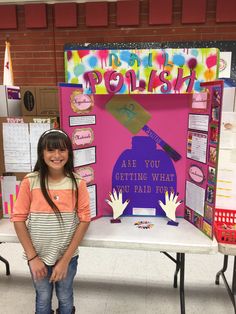 a girl standing in front of a table with writing on it