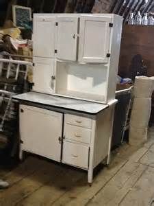 an old fashioned white cabinet with drawers and cupboards on the bottom shelf in a barn