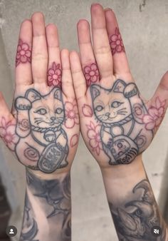 two hands that have tattoos on them and one has an image of a cat in the middle