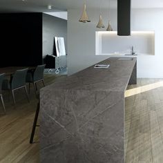 an empty kitchen and dining room are shown in this image, with the counter top made out of marble