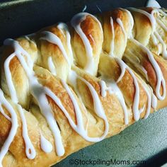 rolls with white icing are lined up on a baking sheet