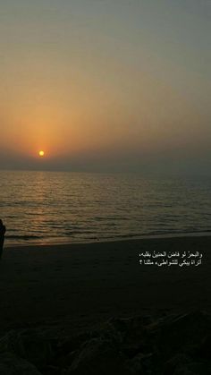 two people sitting on the beach watching the sun rise over the ocean with an inspirational quote written in arabic