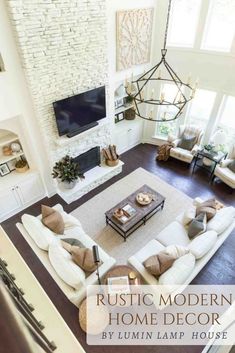 an aerial view of a living room with couches, tables and a television mounted on the wall