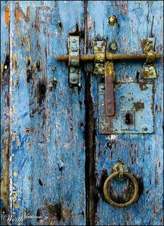 an old blue door with rusted metal handles