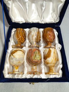 six glass goblets in a blue velvet case