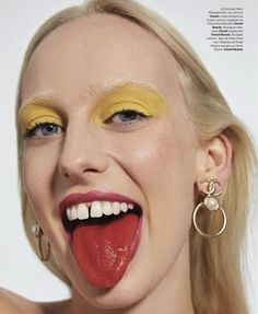 a woman with bright yellow makeup and red lips is making a funny face for the camera