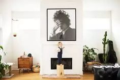 a living room filled with furniture and a painting on the wall above a fire place