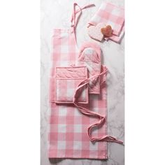 a pink and white checkered table cloth with an oven mitt, pot holder and towel