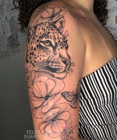 a woman's arm with a leopard and flowers tattoo on her left shoulder, which is black and white