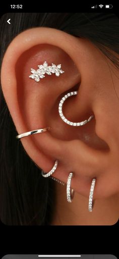 an ear with three different types of piercings on it's sides and one is in the middle