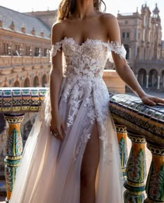 a woman in a white dress standing on a balcony