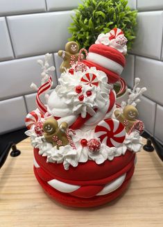 a red and white christmas cake sitting on top of a wooden table